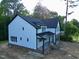 Attractive two-story home featuring white siding, black trim, and a brick-lined, side-entry garage at 301 W College St, Louisburg, NC 27549