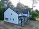 Attractive two-story home featuring white siding, black trim, and a brick-lined, side-entry garage at 301 W College St, Louisburg, NC 27549
