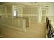 Upstairs hallway with wooden floors, wood railing, and new drywall at 301 W College St, Louisburg, NC 27549