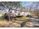 Side view of a ranch home with wooden deck and stairs at 602 E Club Blvd, Durham, NC 27704