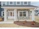Charming front porch with stone accents, white columns, and a stylish front door at 62 Faircox Way # 139, Garner, NC 27529