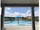 View through the clubhouse of an outdoor swimming pool and splash pad feature on a sunny day at 62 Faircox Way # 139, Garner, NC 27529
