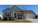 Tan house with a white garage door and landscaping at 670 Meadowtop Cir, Burlington, NC 27217