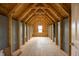 Unfinished attic featuring wood beams, OSB subfloor, and a window at 71 Priming Way, Angier, NC 27501