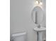 Clean bathroom with a toilet, round mirror, and pedestal sink, ready for your personal touch at 71 Priming Way, Angier, NC 27501