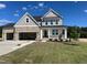 Beautiful two-story home featuring stone accents, a front porch, attached two-car garage, and a well-maintained lawn at 71 Priming Way, Angier, NC 27501