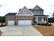 Two-story home boasting a stone facade, two-car garage, and traditional architectural details at 71 Priming Way, Angier, NC 27501