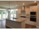 Modern kitchen with stainless steel appliances, a granite island, stylish pendant lights, and white cabinetry at 71 Priming Way, Angier, NC 27501