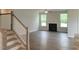 Bright living room features hardwood floors, a cozy fireplace, large windows, and a modern ceiling fan at 71 Priming Way, Angier, NC 27501