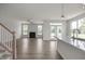 Open-concept living area with fireplace, hardwood floors, and light gray walls that seamlessly connects to the kitchen at 71 Priming Way, Angier, NC 27501