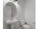 Powder room with a pedestal sink, toilet, and round mirror at 720 Georgias Landing Pkwy # 11, Raleigh, NC 27603