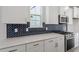 Stylish kitchen featuring a dark backsplash, stainless steel appliances, and white cabinets with bronze hardware at 720 Georgias Landing Pkwy # 11, Raleigh, NC 27603