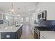 Modern kitchen featuring an island, stainless steel appliances, and a dark backsplash with white cabinets at 720 Georgias Landing Pkwy # 11, Raleigh, NC 27603