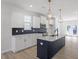 Modern kitchen with white cabinets, dark backsplash, stainless steel appliances, and an island with pendant lights at 720 Georgias Landing Pkwy # 11, Raleigh, NC 27603