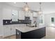 Modern kitchen with white cabinets, dark backsplash, stainless steel appliances, and an island with pendant lights at 720 Georgias Landing Pkwy # 11, Raleigh, NC 27603