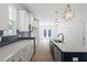 Modern kitchen with stainless steel appliances, dark backsplash, white cabinets, and an island with pendant lights at 720 Georgias Landing Pkwy # 11, Raleigh, NC 27603