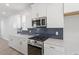 Modern kitchen featuring stainless steel appliances, a dark backsplash, and white cabinets with bronze hardware at 720 Georgias Landing Pkwy # 11, Raleigh, NC 27603