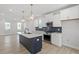 Modern kitchen featuring an island, stainless steel appliances, a dark backsplash and white cabinets at 720 Georgias Landing Pkwy # 11, Raleigh, NC 27603