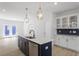 Modern kitchen with stainless steel appliances, an island, white and dark cabinets, and pendant lighting at 720 Georgias Landing Pkwy # 11, Raleigh, NC 27603
