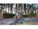 Stone steps leading to a landscaped backyard with trees and planters at 7607 Divot Dr, Sanford, NC 27332