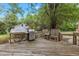 Spacious wooden deck with a grill, seating, and a view of a large white outbuilding at 801 Williamsboro St, Oxford, NC 27565