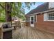 Backyard of brick home featuring a spacious wooden deck with a grill and seating area at 801 Williamsboro St, Oxford, NC 27565