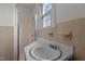 A bright bathroom featuring a pedestal sink with chrome fixtures, shower, and light-colored wall tiles at 801 Williamsboro St, Oxford, NC 27565