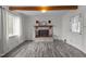 Bright living room with brick fireplace, new flooring, and wooden ceiling beams at 801 Williamsboro St, Oxford, NC 27565