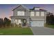 Two-story home with gray siding, stone accents, and a two-car garage at 8701 Maxine St # 43, Willow Springs, NC 27592