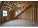 Unfinished attic space featuring exposed wood beams, framing, and a window at 1236 Perry Bluff Dr, Wake Forest, NC 27587