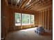 Bright unfinished bedroom space with large windows for natural light and wooden framing under construction at 1236 Perry Bluff Dr, Wake Forest, NC 27587