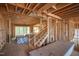 Unfinished interior reveals wooden framing, staircase, open floor plan with lots of natural light under construction at 1236 Perry Bluff Dr, Wake Forest, NC 27587