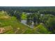 Aerial view of a pond with a fountain surrounded by lawns and mature trees at 1236 Perry Bluff Dr, Wake Forest, NC 27587