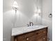 Bathroom with a vanity sink, quartz countertop, and wall-mounted light fixtures at 1313 Enderbury Dr, Raleigh, NC 27614
