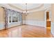 Formal dining room with hardwood floors, wainscoting, and floral window treatments at 1313 Enderbury Dr, Raleigh, NC 27614
