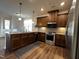 Modern kitchen featuring dark wood cabinets, stainless steel appliances, and light-colored countertops at 133 Walking Path Pl, Hillsborough, NC 27278