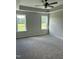 The main bedroom features a tray ceiling, two windows, and soft, neutral carpeting at 185 N Movado Trl, Kenly, NC 27542