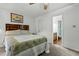 Bedroom features a bed, ceiling fan, doorway to ensuite bathroom, and a barn picture on the wall at 1909 Pearces Rd, Zebulon, NC 27597