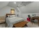 Sloped ceiling bedroom features ceiling fan, desk and bed with accent pillows at 1909 Pearces Rd, Zebulon, NC 27597