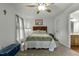 Bedroom with neutral carpet, ceiling fan, and closet space; bathroom doorway to the right of the bedroom at 1909 Pearces Rd, Zebulon, NC 27597