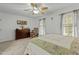 Bedroom with neutral carpet, ceiling fan, dresser, rocking chair, and two windows with curtains at 1909 Pearces Rd, Zebulon, NC 27597