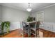 Dining room features wainscoting, wood floors, modern light fixture, and view to outdoors at 1909 Pearces Rd, Zebulon, NC 27597