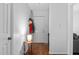 Bright entryway featuring hardwood floors, white walls, table with lamp, and coats hanging on wall at 1909 Pearces Rd, Zebulon, NC 27597