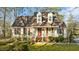 Quaint two-story home featuring a cozy front porch and red shutters, set on a well-manicured lawn at 1909 Pearces Rd, Zebulon, NC 27597