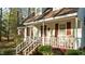 Charming front porch with a red base and mature shrubs at 1909 Pearces Rd, Zebulon, NC 27597