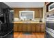 Kitchen featuring wooden cabinets, stainless steel appliances, wood floors, and a pass-through at 1909 Pearces Rd, Zebulon, NC 27597