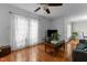 Bright living room featuring hardwood floors, ceiling fan, large window with curtains, and gray sofa at 1909 Pearces Rd, Zebulon, NC 27597