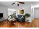 Open-concept living room features hardwood floors, gray sofa, open window to kitchen, and view of dining room at 1909 Pearces Rd, Zebulon, NC 27597