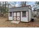 White storage shed with brown trim and wooden ramp at 1909 Pearces Rd, Zebulon, NC 27597