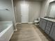 Bathroom with granite countertop, soaking tub, and grey cabinets at 209 Constellation Ct, Benson, NC 27504